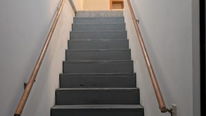 A staircase with wooden handrails and a light-colored wall. - Adorable studio with AC in charming Winfield (Winfield)