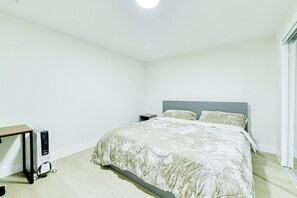 Ein Schlafzimmer mit Bett, Nachttisch und Schreibtisch mit Stuhl.