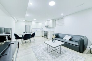 En moderne lejlighed med spiseområde, køkken, opholdsstue og et fladskærms-TV.