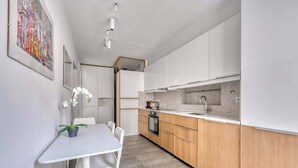 Eine moderne Küche mit weißen Schränken, einer Holz Arbeitsplatte und einem eingebauten Backofen.