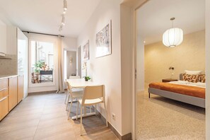 A modern bedroom with a bed, bedside table, and a hanging light fixture. - Terrace Apartment in Heart of St-Germain-des-Prés (Paris)