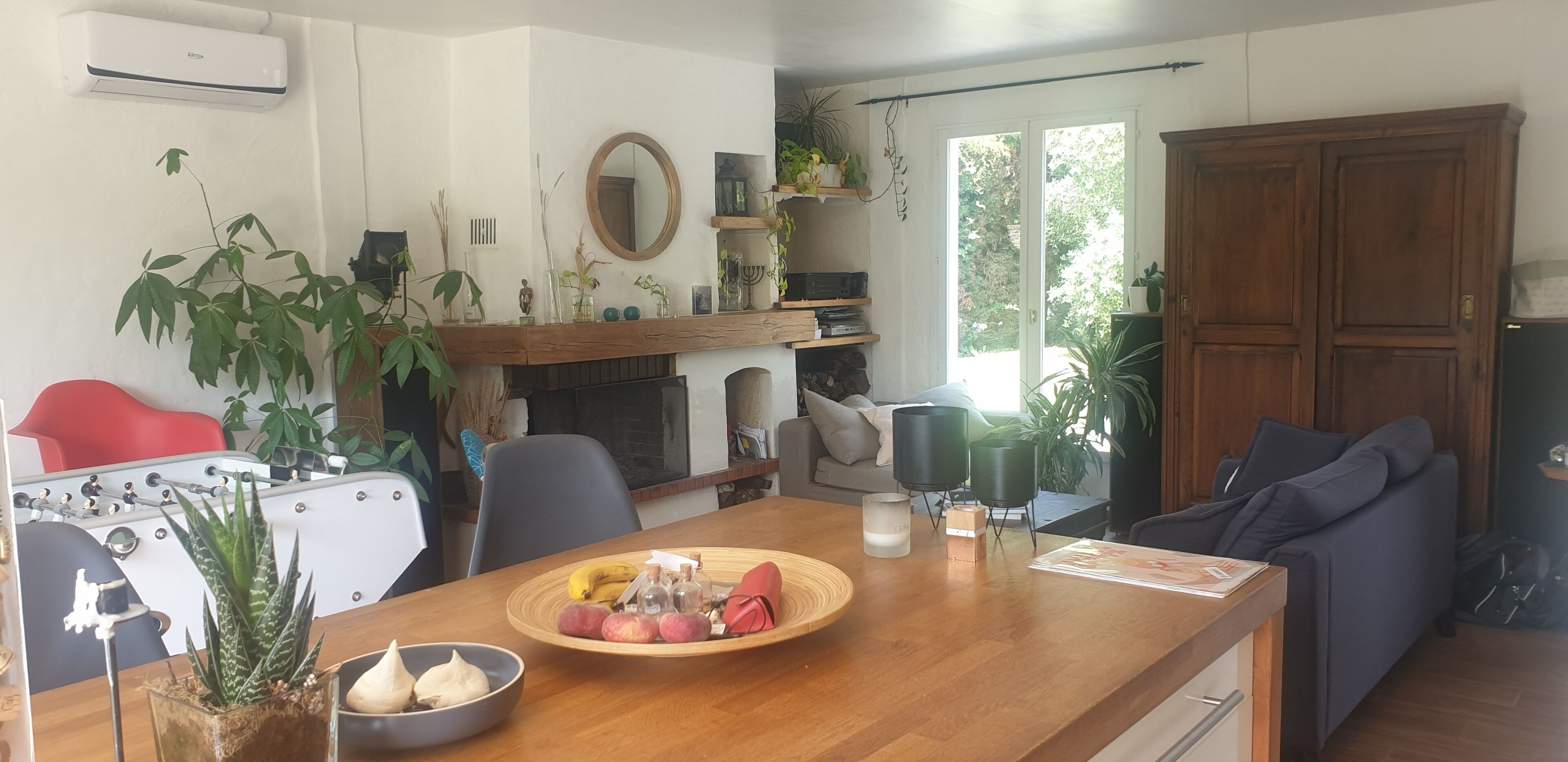 Une cuisine moderne avec un coin repas, un canapé et une cheminée.