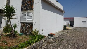 A residential building with a stone facade, a white exterior, and a gravel driveway. - CASA DO PINHEIRO, near Olhos de Água River Beach and the Lake Azul (Pé de Cão)