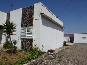 A residential building with a stone facade, a white exterior, and a gravel driveway. - CASA DO PINHEIRO, near Olhos de Água River Beach and the Lake Azul (Pé de Cão)