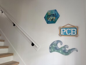 A staircase with white walls and a wooden handrail. - Happy Turtle NEW Renovation• Jacuzzi•Grill (Panama City Beach)