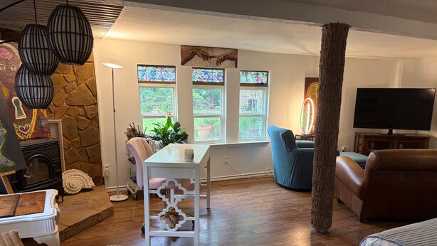 A cozy living room with a stone wall, a fireplace, a television, and a comfortable seating area.