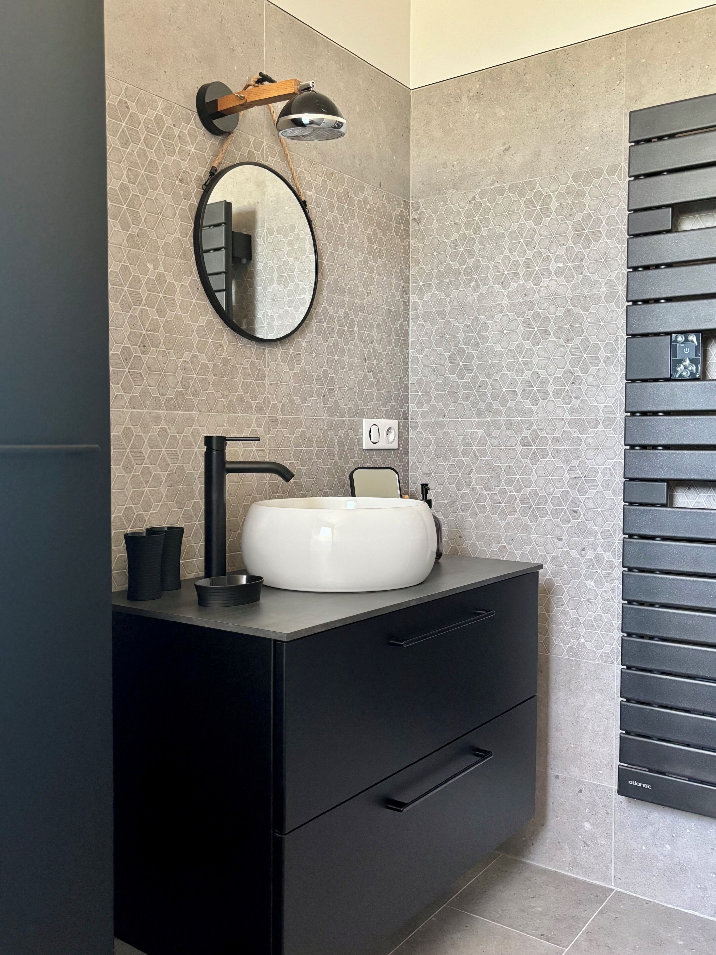 A bathroom with a modern sink, a mirror, and a towel rack.