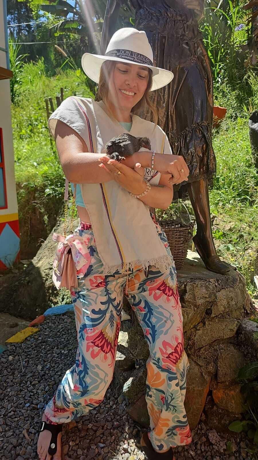 Una persona de pie al aire libre, con una estatua al fondo.