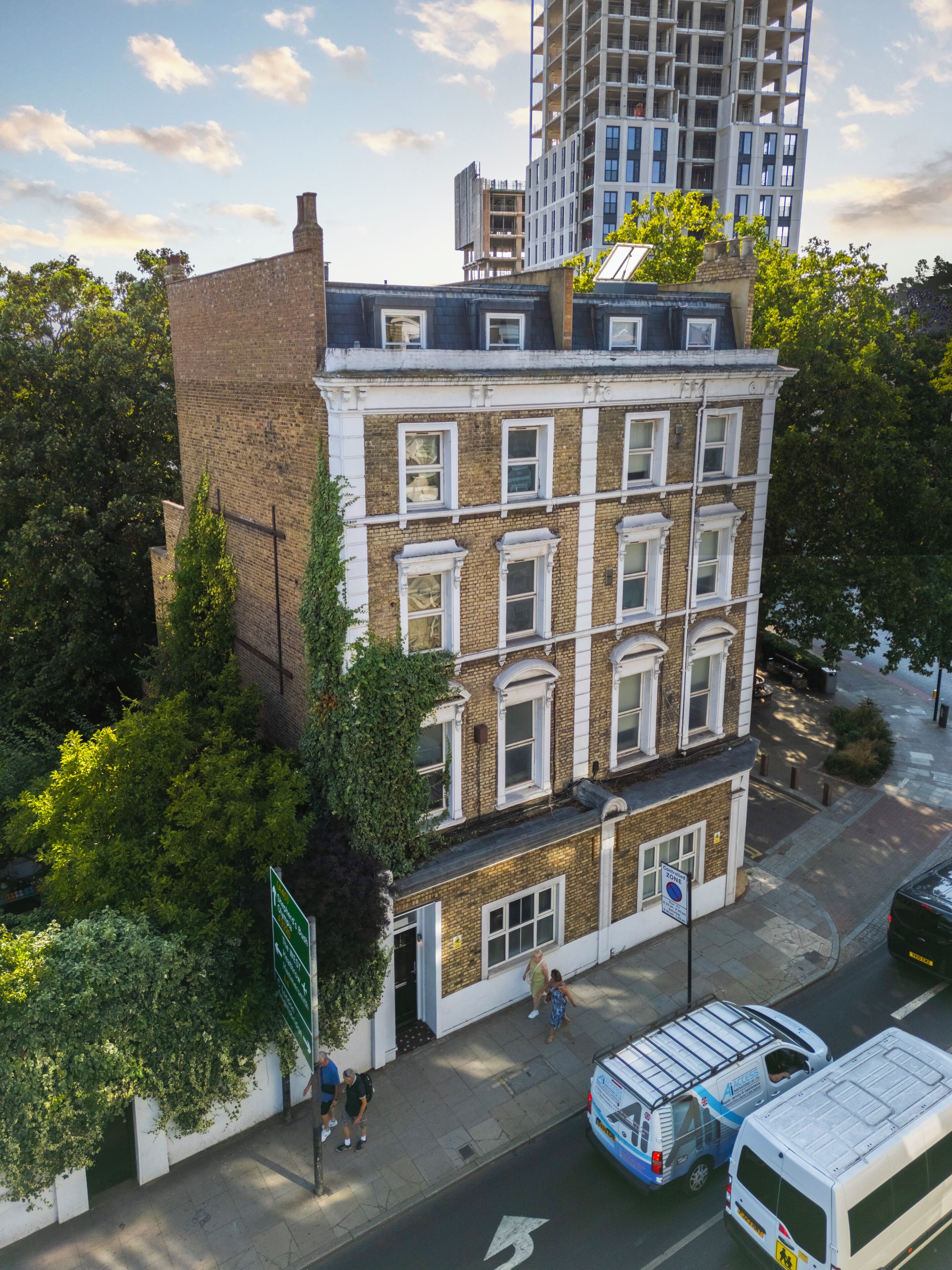 A multi-story building with a brick facade, large windows, and a flat roof.