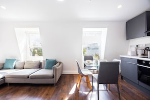 A modern apartment with a living area, dining space, and kitchen. - Earl's Court Residence (London)