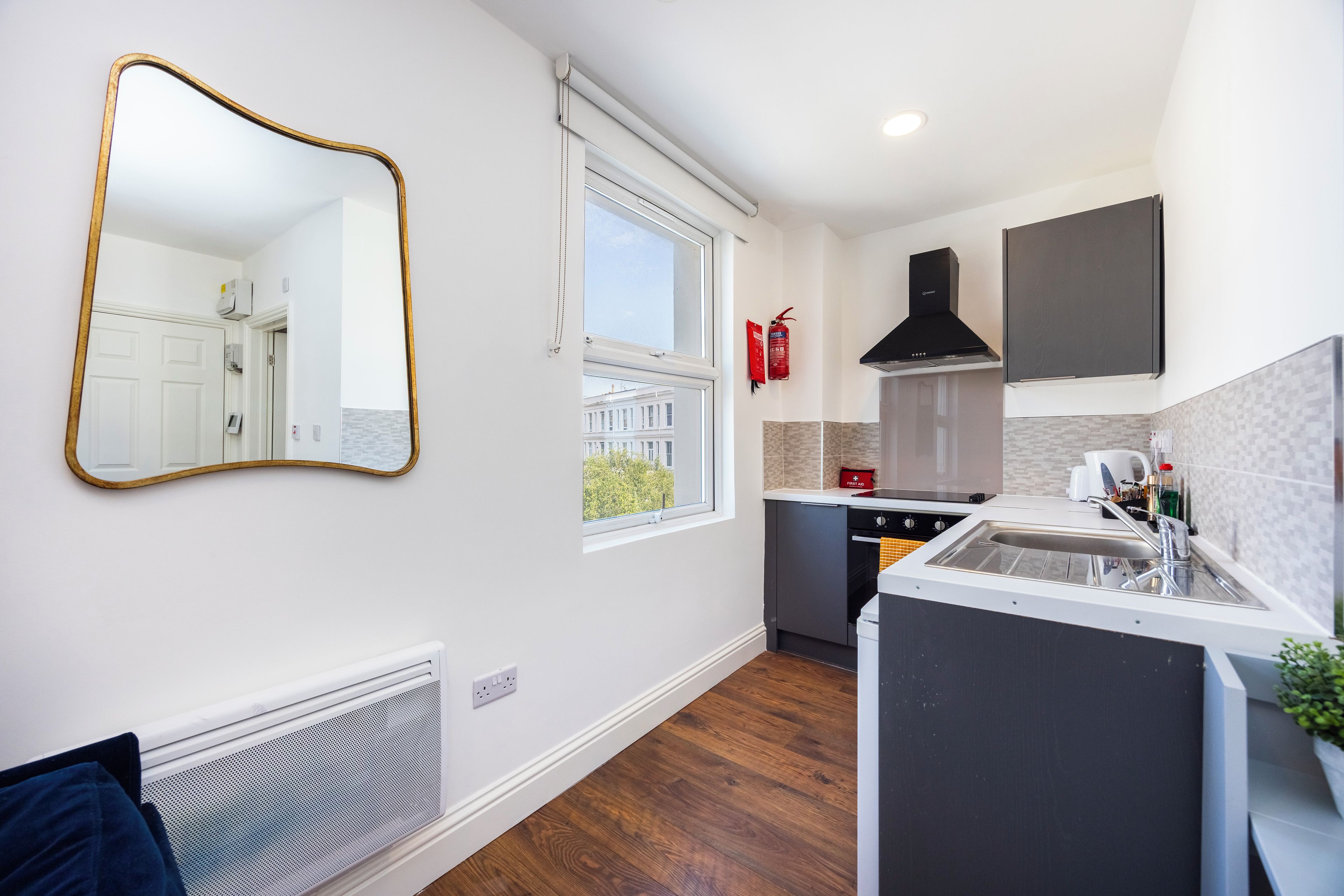 A modern kitchen with a built-in stove, a sink, and a window.