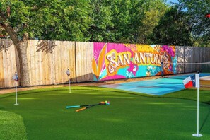 A colorful mural with 'SAN ANTONIO' text, a green lawn, and a pool table. - NEW! Pool, HotTub, Pickleball, Mini Golf + Theater (San Antonio)