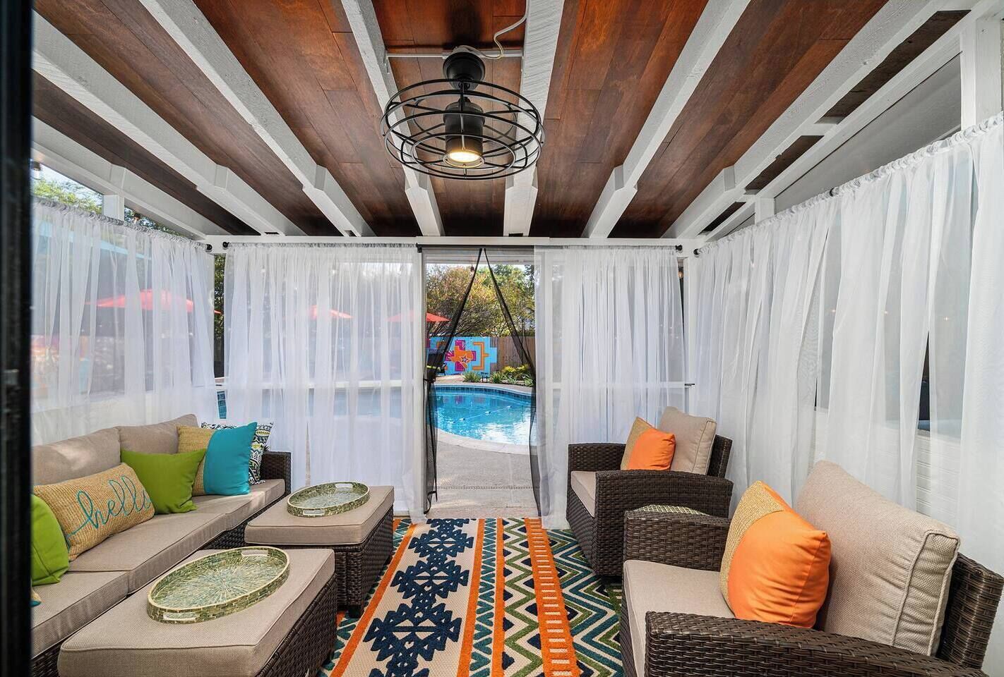 Stylish poolside lounge with cozy seating and breezy enclosed patio charm