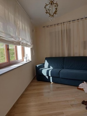 Habitación cuádruple, vista al parque | Área de sala de estar
