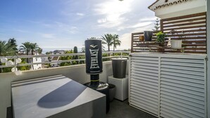A rooftop terrace with a barbecue grill, a trash bin, and a white railing. - Rg133 - Spacious 3 bed Apartment in Prime Location (Marbella)