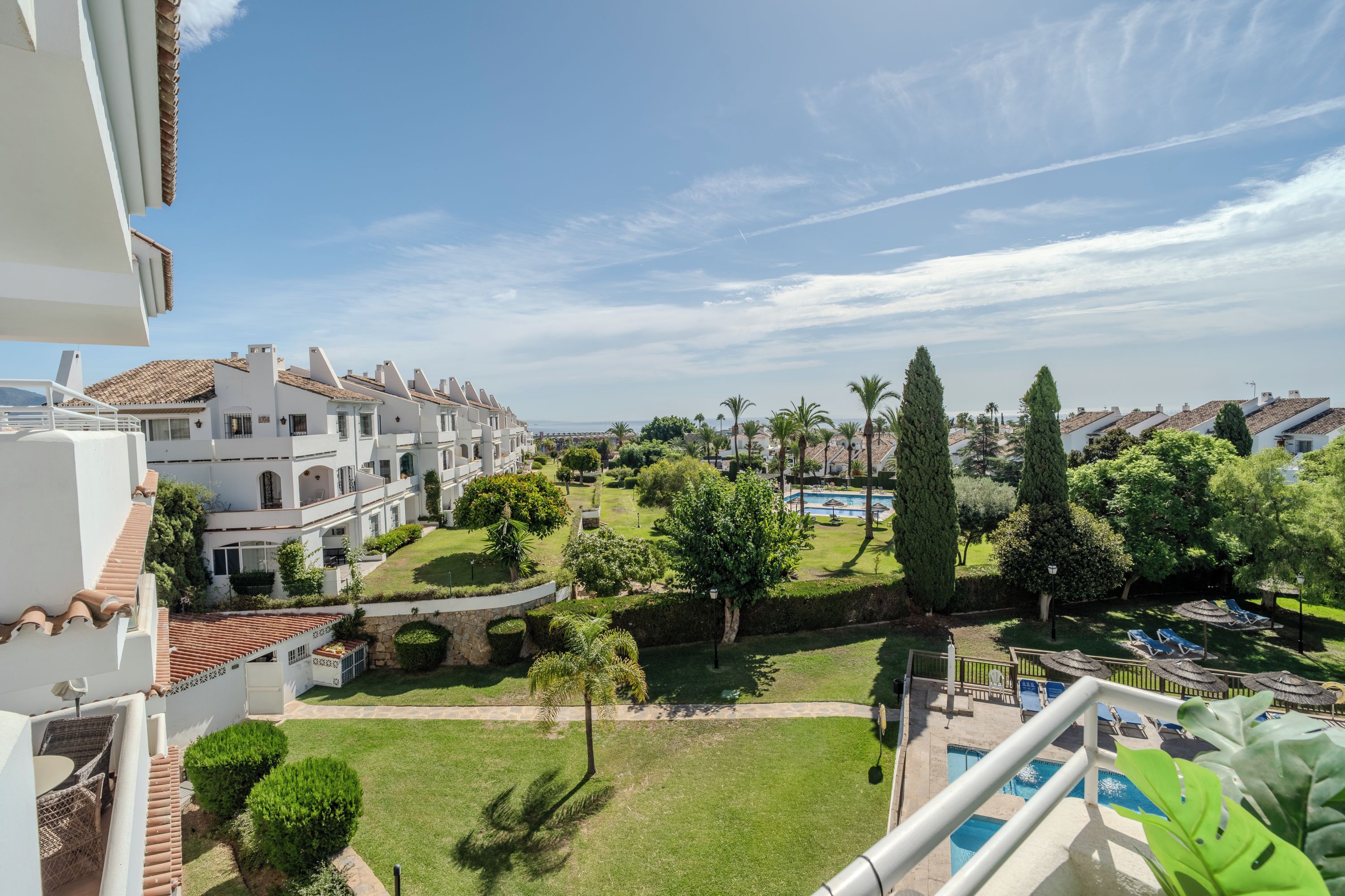 Un quartier résidentiel doté d’une piscine, de pelouses bien entretenues et d’un ciel dégagé.