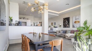 A modern kitchen with a dining area, a living room with a sofa, and a dining table with chairs. - Rg133 - Spacious 3 bed Apartment in Prime Location (Marbella)