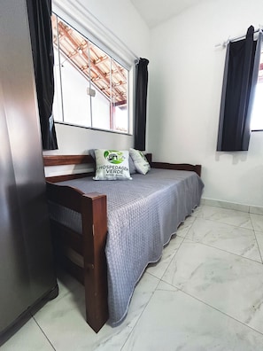 A bedroom with a bed, pillows, a window, and curtains. - Fully furnished apartment, close to the beach and city center. (Armação dos Búzios)