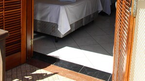 Una habitación de hotel con dos camas, una puerta de madera y un letrero con un número encima.