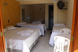 A hotel room with two beds, a fan, a TV, and a small table. - Pousada da Fonte Ltda (Serra Negra)