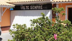 Un edificio con un letrero que dice 'VOLTE SEMPRE' y una entrada con portones.