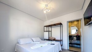 Un dormitorio moderno con cama, mesita de noche, armario y espejo.