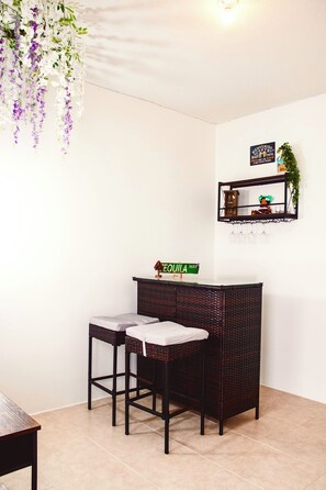 A room with a bar area, two bar stools, a sign reading 'TEQUILA WAY', and hanging purple flowers. - Volcano Views Near Antigua! 3BR Retreat w/ Main-Floor Bedrooms (ciudad vieja)