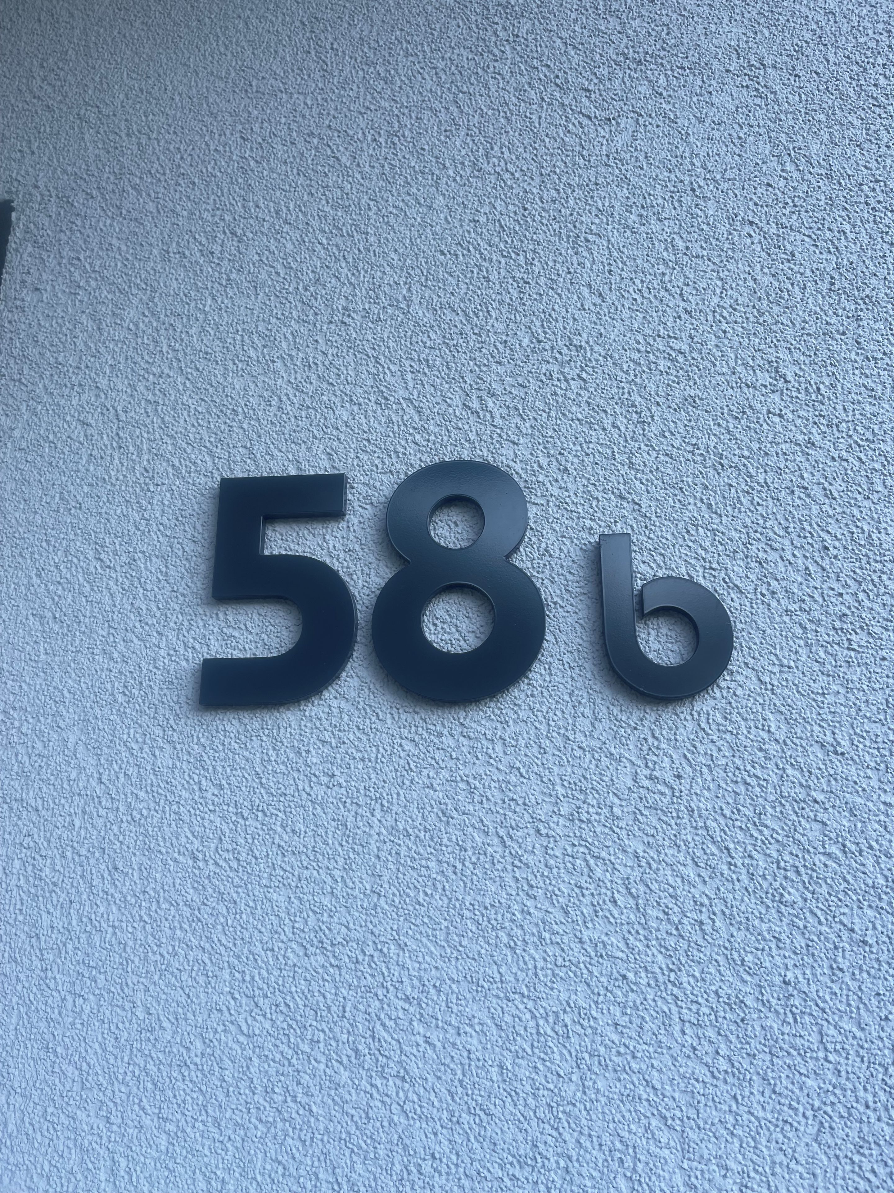 Una señal en la pared con los números '58b' que identifica una propiedad o lugar.