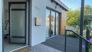 A modern building with a glass door entrance, a mailbox, and a number '586' sign.