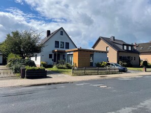 A residential area with modern houses, a paved driveway, and a parked car.