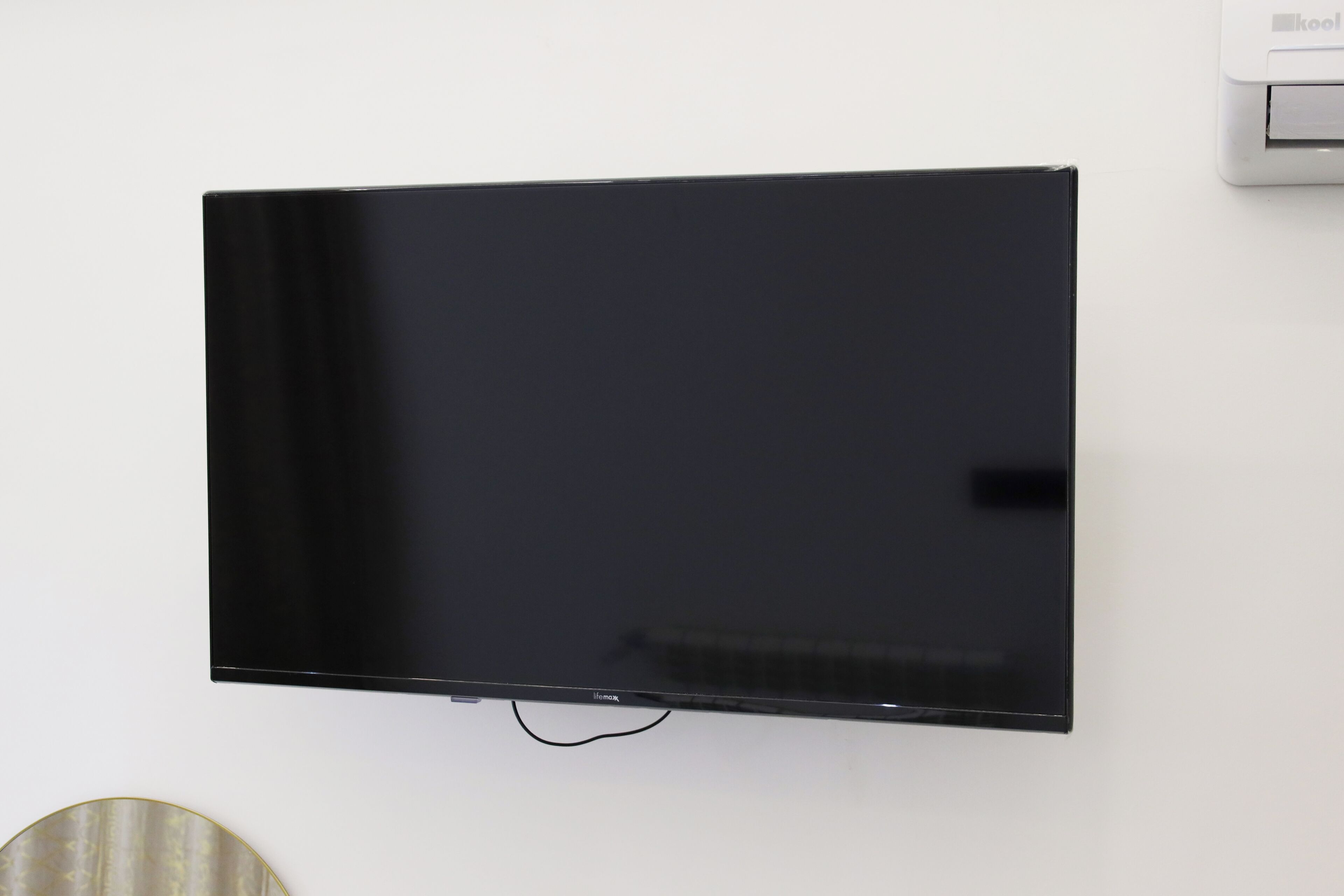 Een flatscreen televisie bevestigd aan een witte muur.