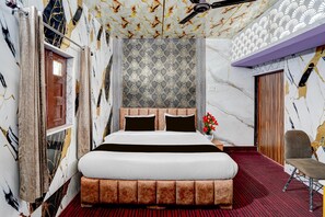 A bedroom with a large bed, a wooden headboard, a red carpet, and a patterned wallpaper. - Classic Nautiyal Home Stay (Vikasnagar)
