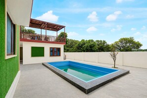 A modern house with a swimming pool, a balcony, and a green wall. - Classic Nautiyal Home Stay (Vikasnagar)