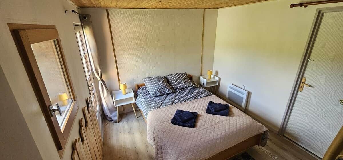 A bedroom with a bed, bedside tables, a wardrobe, and a window.