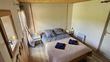 A bedroom with a bed, bedside tables, a wardrobe, and a window.