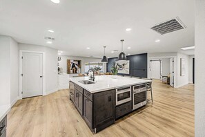 A spacious kitchen with a large island, modern appliances, and pendant lighting. - NEW| The Fairmont @ Kierland | Pool, Spa & Daybeds (Scottsdale)