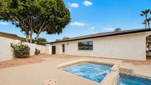 A residential property with a swimming pool, a white exterior wall, and a large tree. - NEW| The Fairmont @ Kierland | Pool, Spa & Daybeds (Scottsdale)