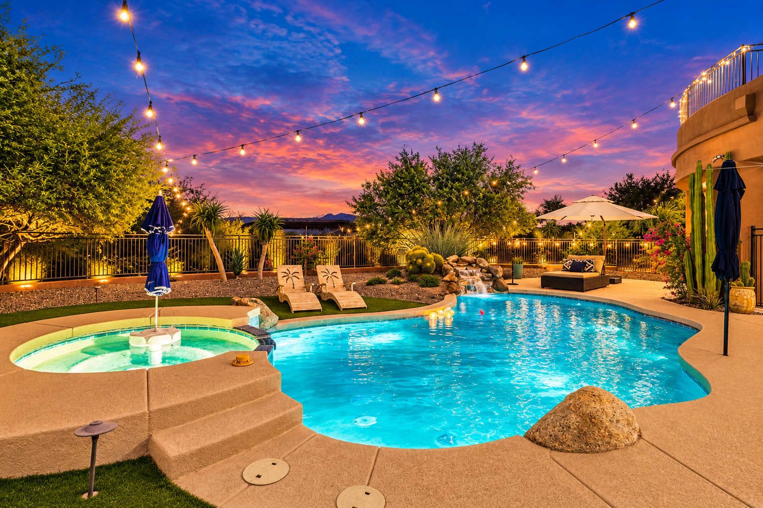 A backyard with a swimming pool, lounge chairs, and string lights.