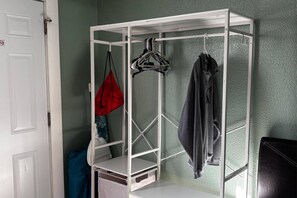 A white metal wardrobe with shelves and hanging space, located in a room with green walls. - 1BR Studio Best Location, Siesta Key, 8mins, 2 People (Sarasota)