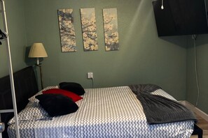 A bed with patterned bedding, a lamp, and three wall-mounted paintings. - 1BR Studio Best Location, Siesta Key, 8mins, 2 People (Sarasota)