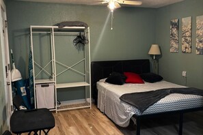 Ein Schlafzimmer mit Bett, Schrank, Stuhl und Schreibtisch.