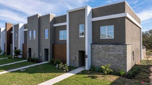 Un immeuble d’appartements moderne, doté d’une façade uniforme, de nombreuses fenêtres et d’une pelouse bien entretenue.