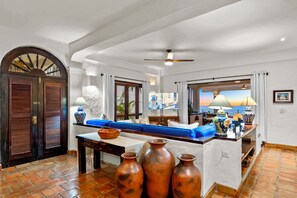 Ein geräumiger Wohnbereich mit großem Fenster, einem blauen Sofa, einem Holztisch und einer dekorativen Vase.