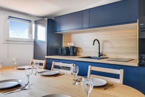 Una cocina moderna con estufa integrada, un lavamanos y un ventanal sobre la encimera.