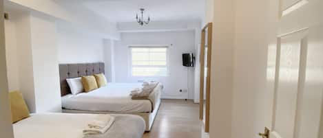 Une chambre d’hôtel avec deux lits, une télévision et une fenêtre.