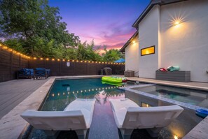 A swimming pool with lounge chairs, a covered seating area, and string lights. - Cozy City Retreat with Apartment, 4 bedroom, 3.5 bath, large outside pool & spa (Austin)