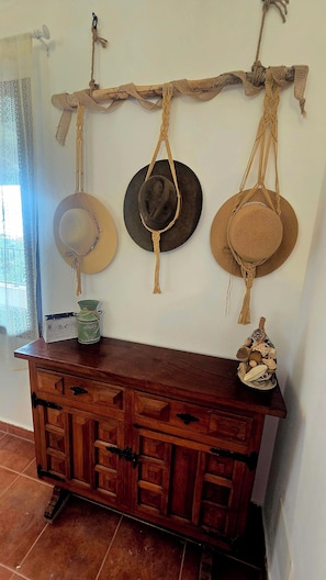 A rustic wooden dresser with multiple drawers and a woven branch above it. - The Haven of Happiness (Fataga)