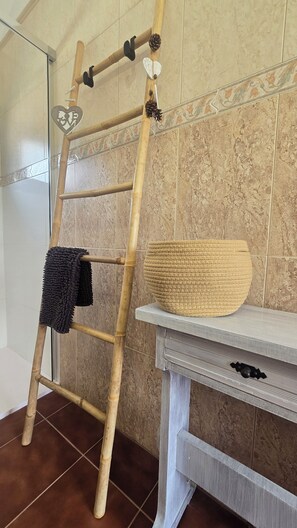 A bathroom with a wooden ladder, a woven basket, and a towel rack. - The Haven of Happiness (Fataga)