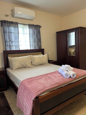 Ein Hotelzimmer mit einem Bett, einem Kleiderschrank, einem Spiegel und einer Klimaanlage.
