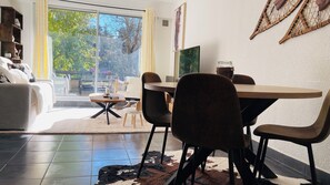 Ein modernes Wohnzimmer mit Essbereich, großen Fenstern und Blick ins Freie.